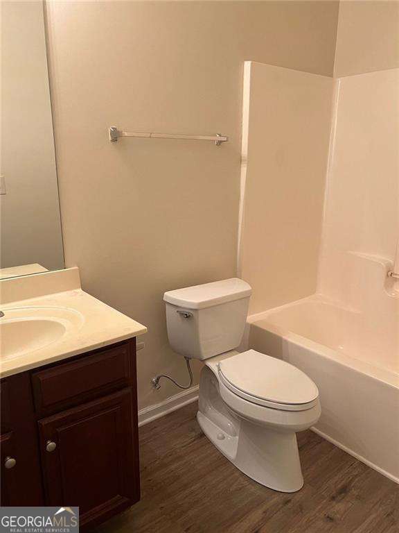 5123 Upper Elm St, Atlanta, GA 30349 - bathroom with toilet, wood finished floors, vanity,  shower combination, and baseboards