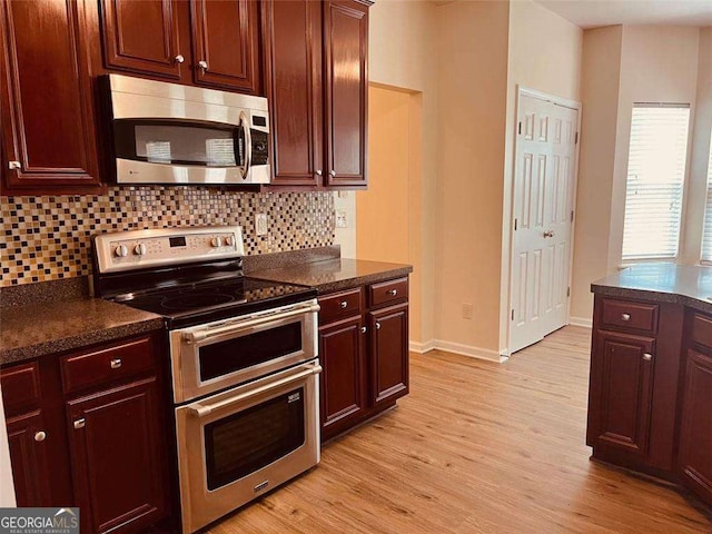 5123 Upper Elm St, Atlanta, GA 30349 - kitchen with stainless steel appliances, light wood finished floors, tasteful backsplash, and baseboards