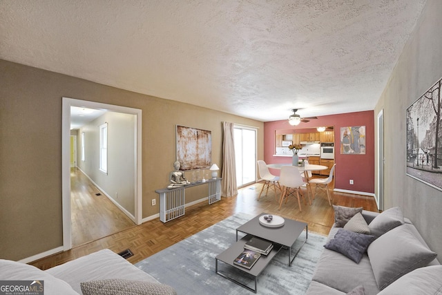 2394 Burch Cir NE, Brookhaven, GA 30319 - living room with a textured ceiling, baseboards, ceiling fan, and parquet flooring
