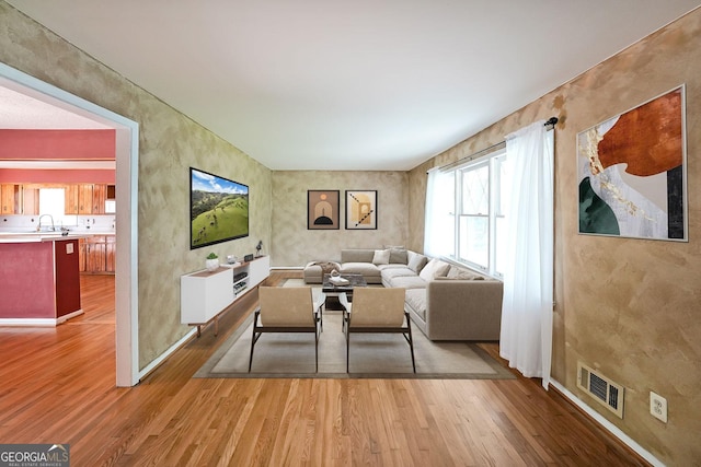 2394 Burch Cir NE, Brookhaven, GA 30319 - living area featuring wood finished floors, healthy amount of natural light, and baseboards