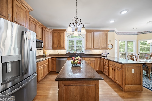 569 Fairway Dr, Woodstock, GA 30189 - kitchen with appliances with stainless steel finishes, a peninsula, a chandelier, plenty of natural light, and crown molding