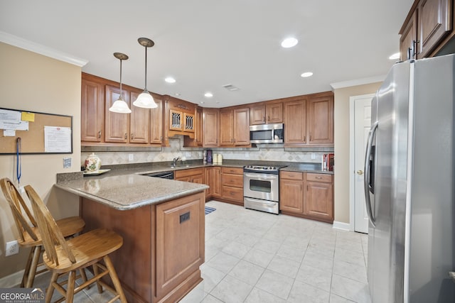 569 Fairway Dr, Woodstock, GA 30189 - kitchen featuring stainless steel appliances, a peninsula, crown molding, decorative backsplash, and brown cabinets