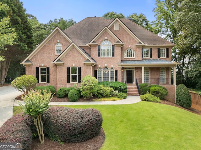 10135 High Falls Pointe, Johns Creek, GA 30022 - colonial-style house featuring brick siding, covered porch, and a front lawn