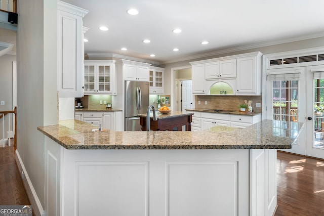 10135 High Falls Pointe, Johns Creek, GA 30022 - kitchen with freestanding refrigerator, dark wood-style flooring, ornamental molding, black electric cooktop, and tasteful backsplash