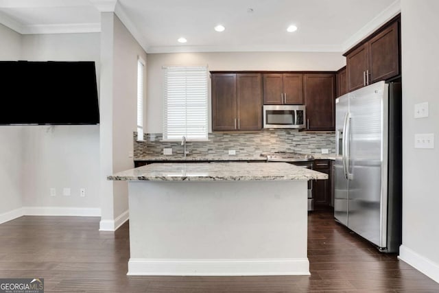 3005 Devoncroft St SE, Smyrna, GA 30080 - kitchen featuring appliances with stainless steel finishes, tasteful backsplash, dark brown cabinetry, baseboards, and crown molding