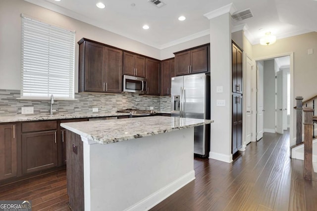 3005 Devoncroft St SE, Smyrna, GA 30080 - kitchen featuring stainless steel appliances, backsplash, dark wood finished floors, crown molding, and dark brown cabinets