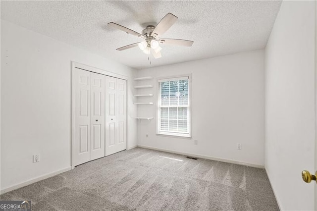 4956 Braeburn Trce NW, Acworth, GA 30102 - unfurnished bedroom with carpet flooring, a textured ceiling, baseboards, a closet, and ceiling fan