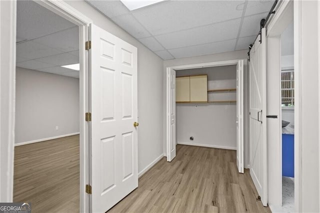 4956 Braeburn Trce NW, Acworth, GA 30102 - hall featuring a drop ceiling, a barn door, light wood finished floors, and baseboards
