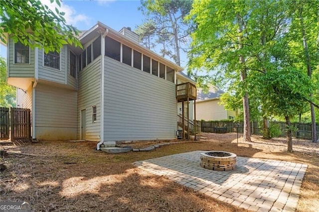 4956 Braeburn Trce NW, Acworth, GA 30102 - back of property with an outdoor fire pit, a fenced backyard, a patio area, a chimney, and a sunroom