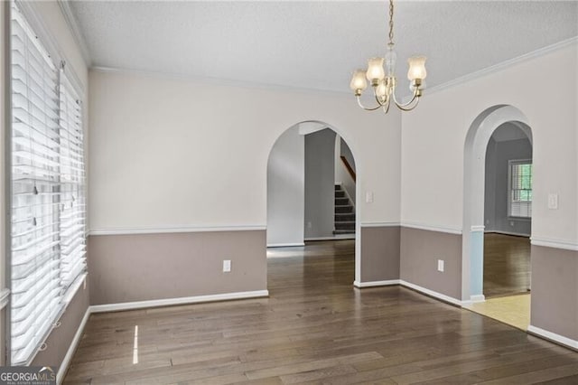 4956 Braeburn Trce NW, Acworth, GA 30102 - spare room with arched walkways, a chandelier, wood finished floors, crown molding, and baseboards