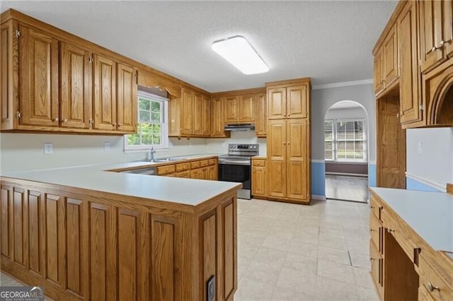 4956 Braeburn Trce NW, Acworth, GA 30102 - kitchen featuring electric range, light countertops, brown cabinetry, a peninsula, and crown molding
