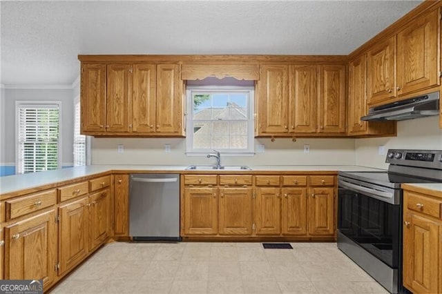 4956 Braeburn Trce NW, Acworth, GA 30102 - kitchen with stainless steel appliances, under cabinet range hood, a sink, brown cabinets, and ornamental molding