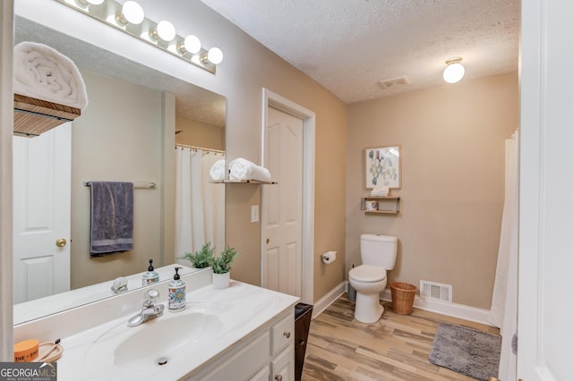 2005 Ashton Pointe Dr, Dacula, GA 30019 - bathroom featuring vanity, wood finished floors, toilet, a textured ceiling, and baseboards