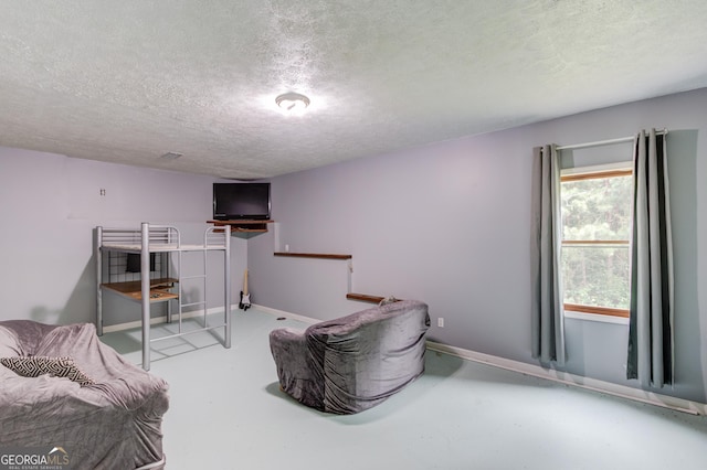 2005 Ashton Pointe Dr, Dacula, GA 30019 - bedroom featuring a textured ceiling, baseboards, and concrete flooring