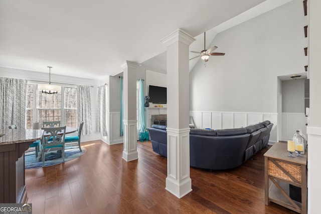 2995 Barimore Pl, Dacula, GA 30019 - living room featuring a wainscoted wall, ceiling fan, dark wood-style floors, vaulted ceiling, and ornate columns