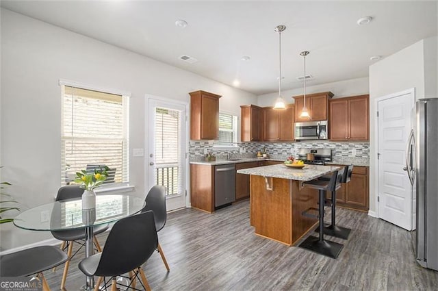 152 Malbone St SW, Cartersville, GA 30120 - kitchen with stainless steel appliances, a kitchen island, decorative backsplash, dark wood-style floors, and a breakfast bar