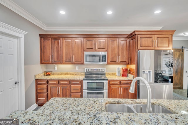 2717 Old Eastman Rd, Cadwell, GA 31009 - kitchen featuring appliances with stainless steel finishes, crown molding, a sink, light stone counters, and brown cabinets