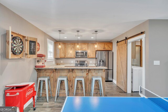 2717 Old Eastman Rd, Cadwell, GA 31009 - kitchen featuring appliances with stainless steel finishes, wood finished floors, a peninsula, a barn door, and recessed lighting