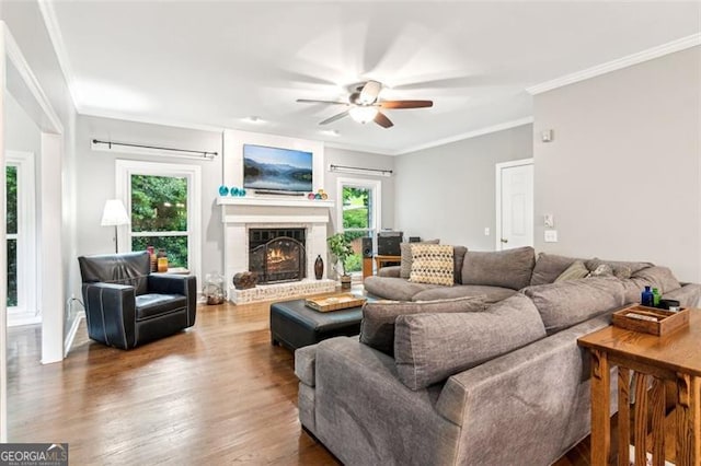 2220 Cape Courage Way, Suwanee, GA 30024 - living room featuring a ceiling fan, healthy amount of natural light, wood finished floors, a fireplace, and crown molding