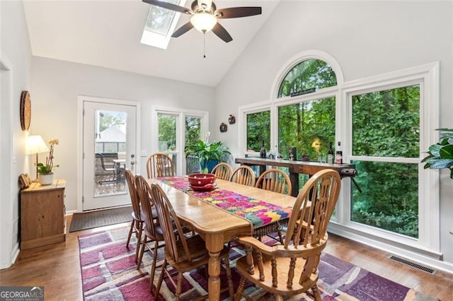 2220 Cape Courage Way, Suwanee, GA 30024 - dining area with high vaulted ceiling, a ceiling fan, wood finished floors, and a skylight