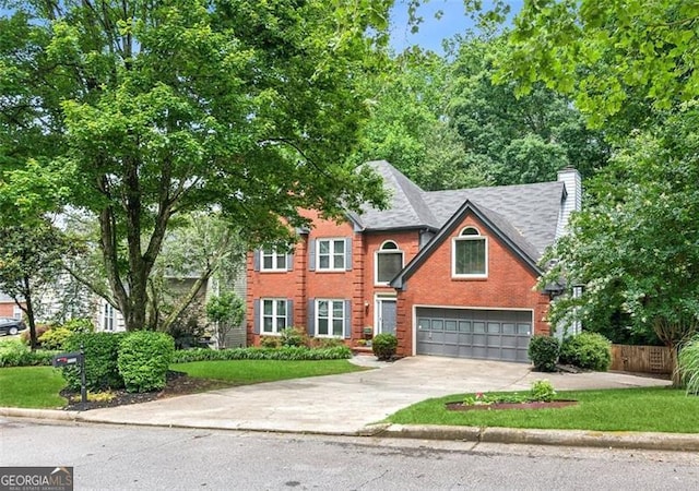 2220 Cape Courage Way, Suwanee, GA 30024 - traditional-style home with driveway, an attached garage, a chimney, and brick siding