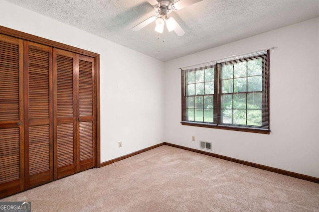 272 Creek Ct SW, Marietta, GA 30064 - unfurnished bedroom featuring light carpet, a textured ceiling, a closet, baseboards, and ceiling fan