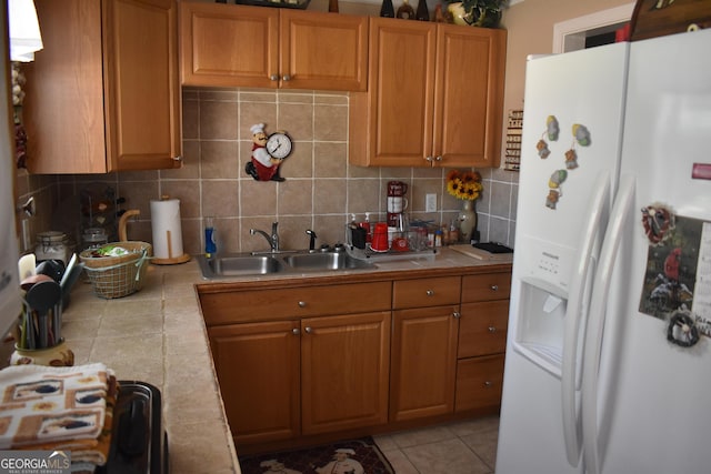 3400 Scott Dr, Austell, GA 30106 - kitchen featuring white fridge with ice dispenser, tile counters, tasteful backsplash, light tile patterned floors, and brown cabinets