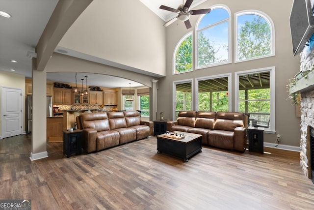 149 Highland Rd S, Dahlonega, GA 30533 - living room with a ceiling fan, a high ceiling, wood finished floors, baseboards, and a fireplace