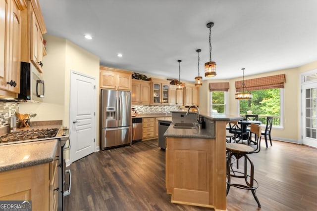 149 Highland Rd S, Dahlonega, GA 30533 - kitchen featuring appliances with stainless steel finishes, a sink, a kitchen bar, dark wood finished floors, and decorative backsplash
