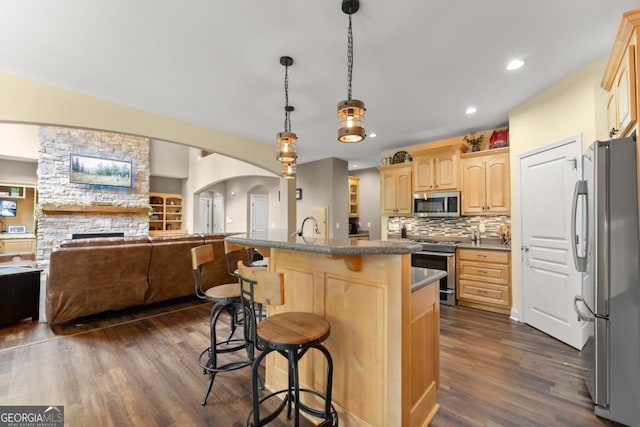149 Highland Rd S, Dahlonega, GA 30533 - kitchen with appliances with stainless steel finishes, light brown cabinets, open floor plan, dark wood-type flooring, and a breakfast bar area
