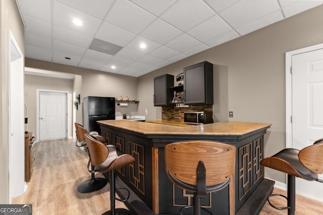 149 Highland Rd S, Dahlonega, GA 30533 - bar area featuring freestanding refrigerator, light wood-type flooring, a drop ceiling, stainless steel microwave, and baseboards
