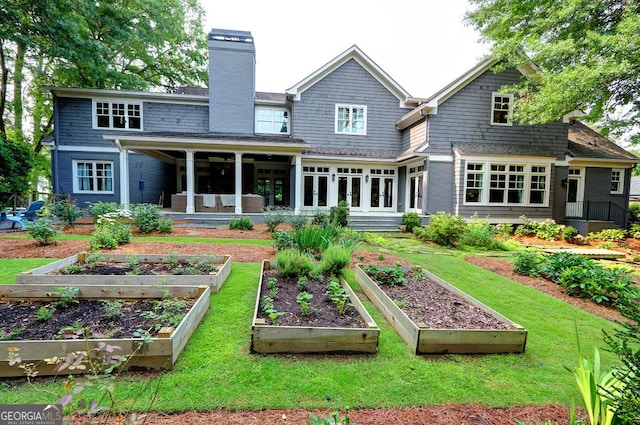 1178 Chambord Way NE, Brookhaven, GA 30319 - back of house featuring a vegetable garden, a chimney, a lawn, and a sunroom