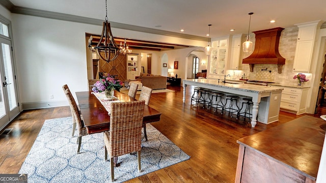 1178 Chambord Way NE, Brookhaven, GA 30319 - dining space featuring a chandelier, ornamental molding, arched walkways, dark wood finished floors, and recessed lighting
