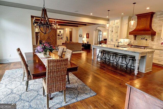 1178 Chambord Way NE, Brookhaven, GA 30319 - dining area with arched walkways, a chandelier, dark wood-type flooring, recessed lighting, and baseboards