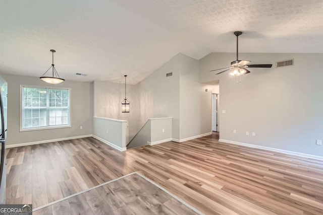 275 Mountain Way, Covington, GA 30016 - unfurnished living room featuring lofted ceiling, wood finished floors, a textured ceiling, and a ceiling fan
