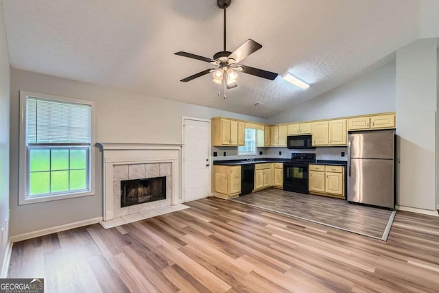 275 Mountain Way, Covington, GA 30016 - kitchen featuring black appliances, vaulted ceiling, plenty of natural light, ceiling fan, and light wood finished floors