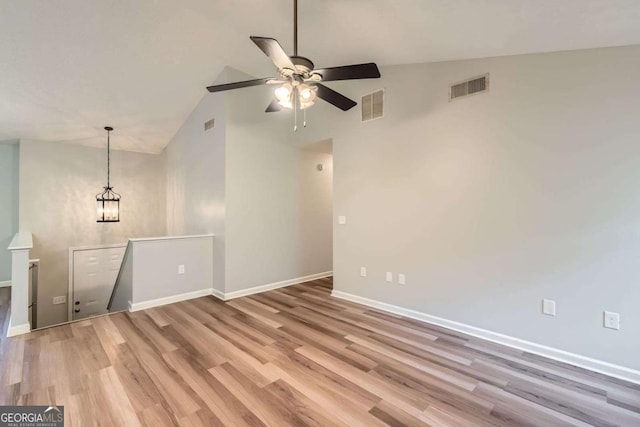 275 Mountain Way, Covington, GA 30016 - unfurnished living room with high vaulted ceiling, ceiling fan, light wood-type flooring, and a chandelier