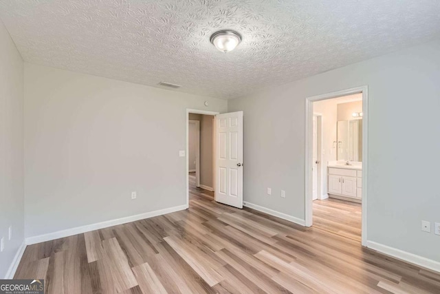 275 Mountain Way, Covington, GA 30016 - unfurnished bedroom featuring light wood-style floors and a textured ceiling