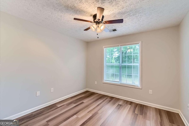 275 Mountain Way, Covington, GA 30016 - unfurnished room with wood finished floors, a ceiling fan, and a textured ceiling
