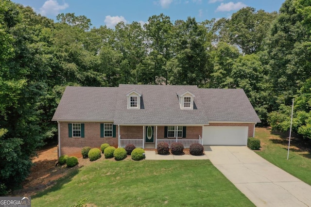 225 Chinns Way, Hampton, GA 30228 - cape cod house featuring covered porch, brick siding, a front yard, driveway, and an attached garage