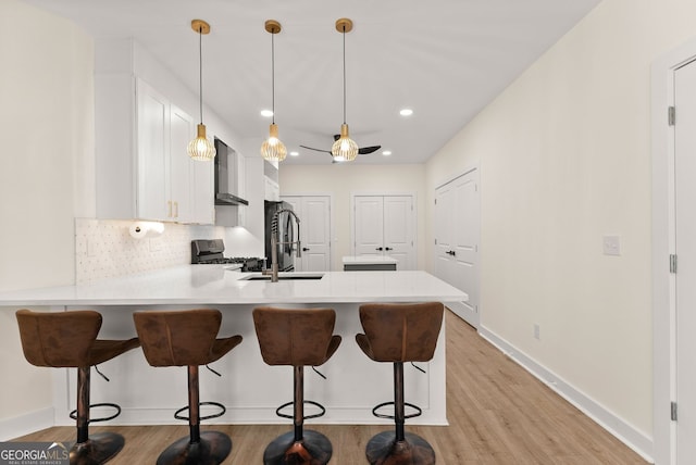 1421 Lane Creek Dr, Bishop, GA 30621 - kitchen with stove, a peninsula, light countertops, light wood-style floors, and tasteful backsplash