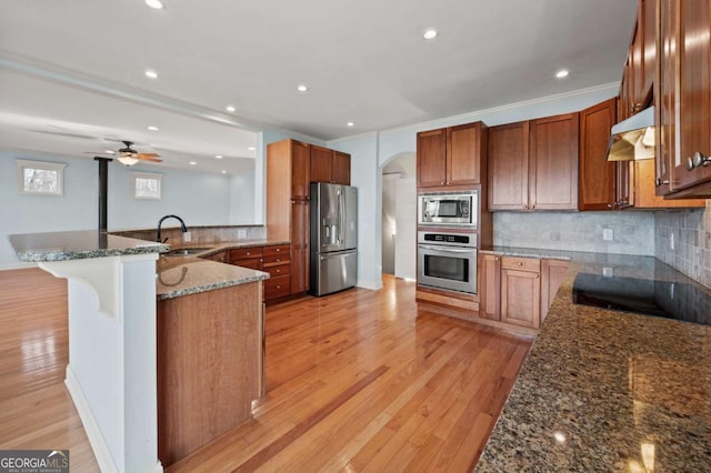 100 Oboe Ct, Ellijay, GA 30540 - kitchen with appliances with stainless steel finishes, under cabinet range hood, a sink, dark stone counters, and tasteful backsplash