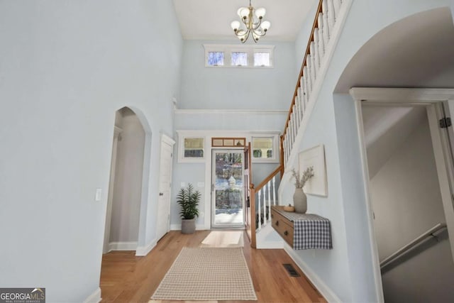 100 Oboe Ct, Ellijay, GA 30540 - foyer entrance with arched walkways, stairway, a chandelier, wood finished floors, and a towering ceiling