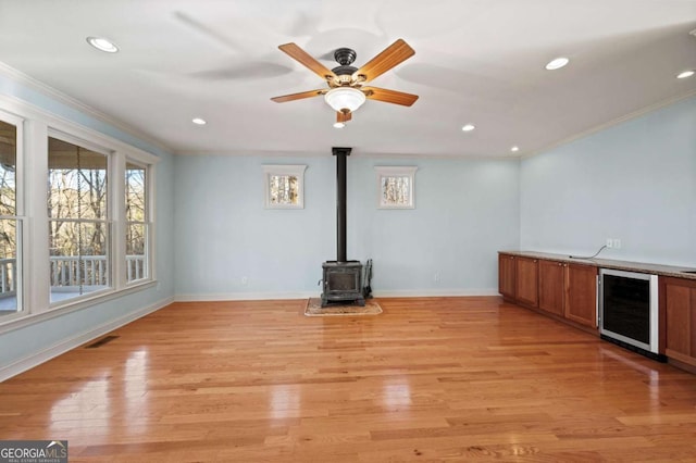 100 Oboe Ct, Ellijay, GA 30540 - unfurnished living room with beverage cooler, crown molding, baseboards, a wood stove, and recessed lighting