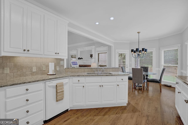 1304 Swallows Walk, Grayson, GA 30017 - kitchen featuring dishwasher, a sink, a chandelier, light wood finished floors, and backsplash
