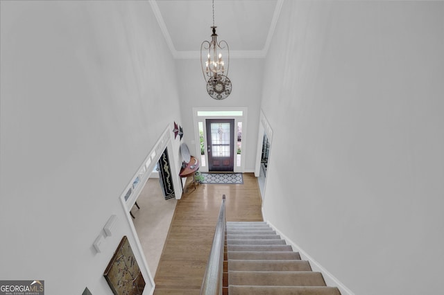 1304 Swallows Walk, Grayson, GA 30017 - foyer featuring crown molding, a chandelier, a high ceiling, wood finished floors, and stairs