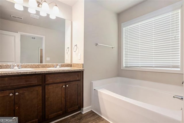 422 Dublin Way, Dallas, GA 30132 - full bathroom featuring double vanity, wood finished floors, a garden tub, and plenty of natural light