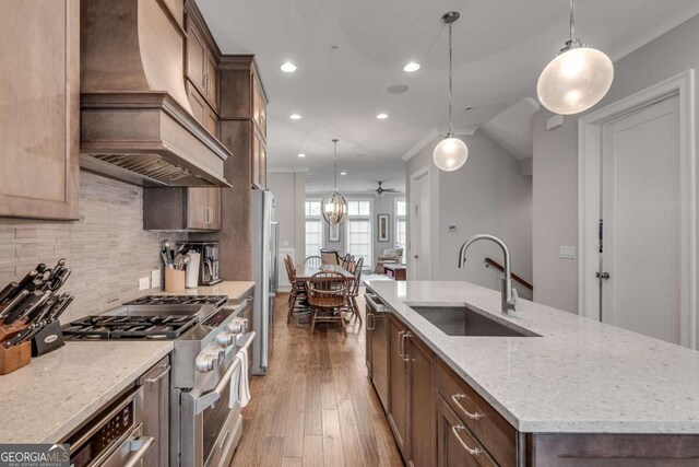 345 Glen Iris Dr NE Unit 3, Atlanta, GA 30312 - kitchen with stainless steel appliances, wall chimney exhaust hood, a center island with sink, recessed lighting, and decorative backsplash