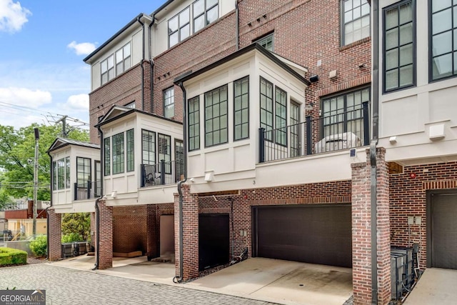 345 Glen Iris Dr NE Unit 3, Atlanta, GA 30312 - rear view of property with brick siding, an attached garage, and a sunroom