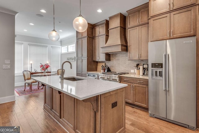 345 Glen Iris Dr NE Unit 3, Atlanta, GA 30312 - kitchen featuring stainless steel refrigerator with ice dispenser, custom range hood, a kitchen island with sink, decorative backsplash, and light wood-style flooring